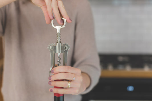 opening a bottle of wine using wing corkscrew